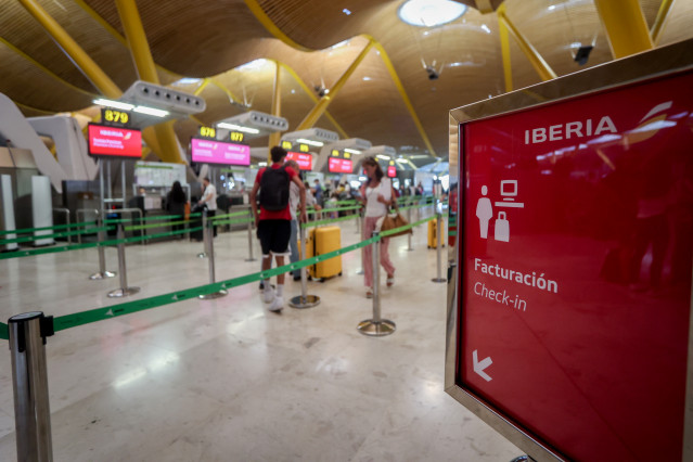 Archivo - Varios pasajeros esperan para obtener sus tarjetas de embarque y facturar su equipaje en el día en que ha dado comienzo una huelga de los tripulantes de cabina de Iberia Express, en la T4 del Aeropuerto Adolfo Suárez Madrid-Barajas, a 28 de agos