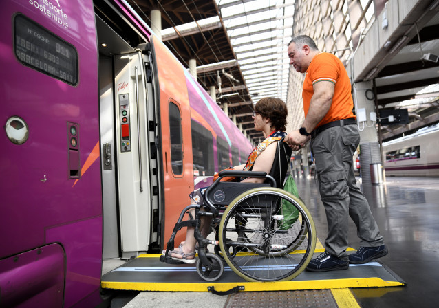 Archivo - Un asistente de Adif Acerca ayuda al embarque de una persona en un tren