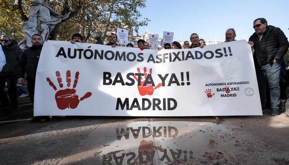Manifestantes portan pancarta con lema 'Autónomos asfixiados!! Basta ya!! Madrid' durante la manifestación de autónomos convocados por la Plataforma por la Dignidad de los Autónomos, a 30 de novie
