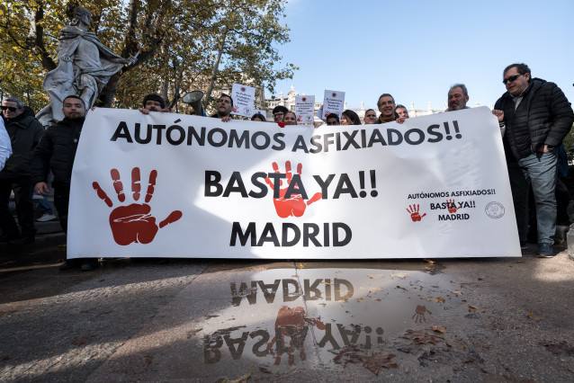 Manifestantes portan pancarta con lema 'Autónomos asfixiados!! Basta ya!! Madrid' durante la manifestación de autónomos convocados por la Plataforma por la Dignidad de los Autónomos, a 30 de noviembre de 2025, en Madrid (España).