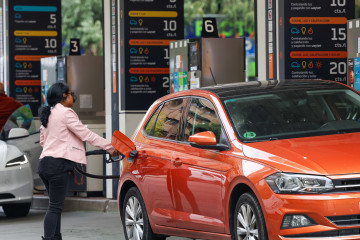 Archivo - Una mujer repostando en una gasolinera