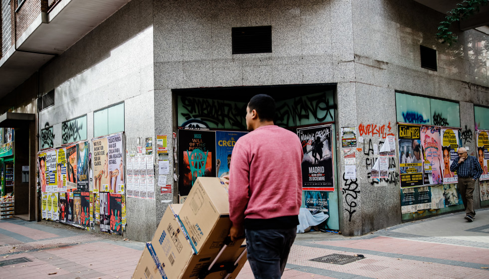 Archivo - Un repartidor carga con varias cajas.