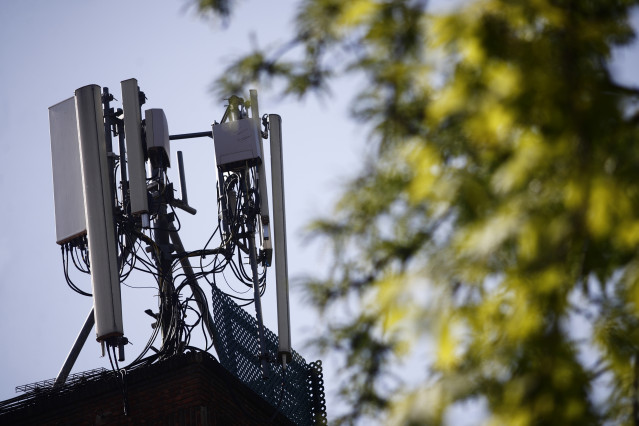 Archivo - Imagen de una antena de telefonía en el tejado de una casa en la ciudad de Madrid.