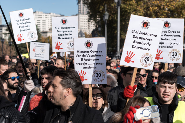 Manifestantes portan pancartas con lemas 'Mientras otros se van de vacaciones, el autónomo trabaja... y paga sanciones'