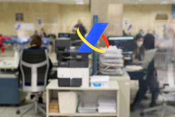 Archivo - Varios empleados trabajan en una oficina de la Agencia Tributaria