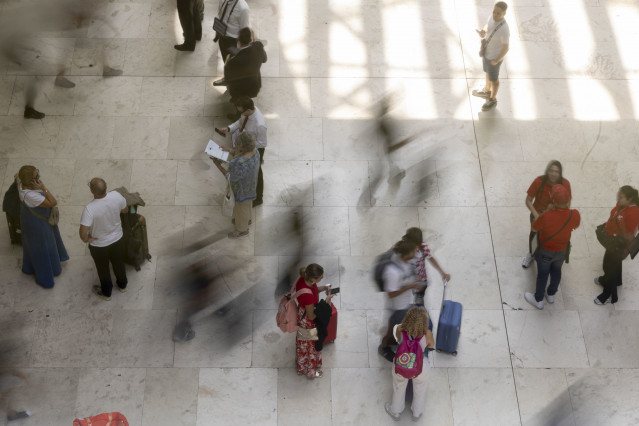 Archivo - Varias personas con maletas, en el Aeropuerto Adolfo Suárez Madrid-Barajas.