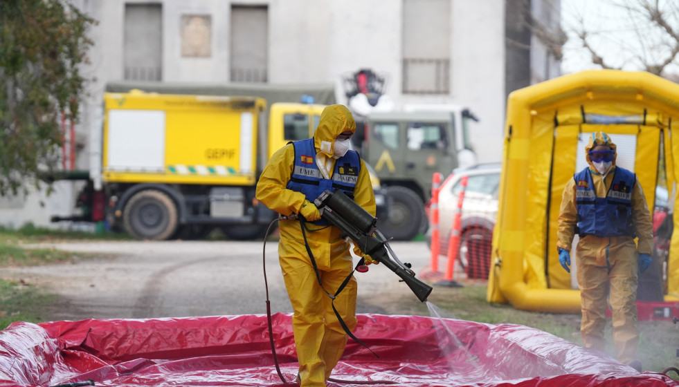 Un miembro de la UME desinfecta vehiculos