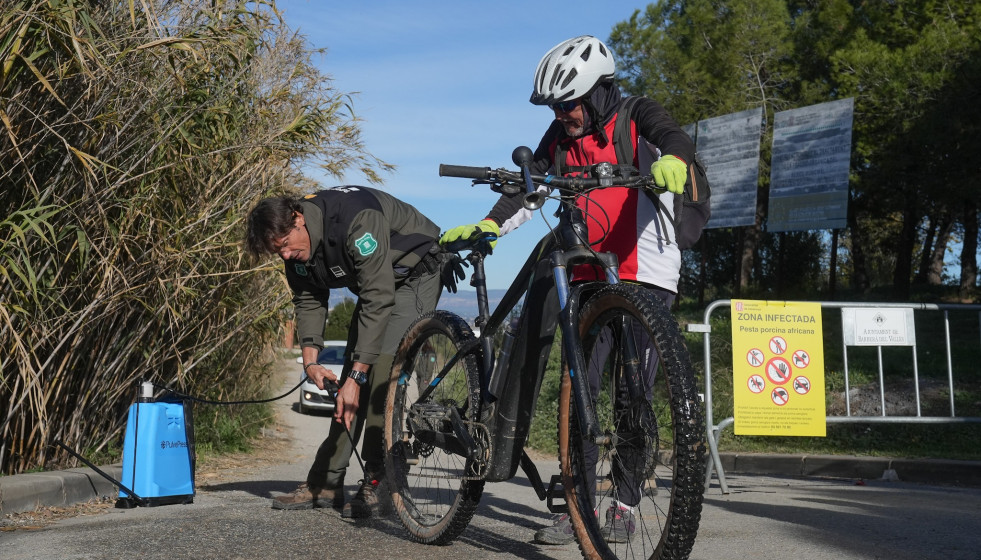 Un efectivo de Agents Rurals desinfecta una bicicleta en un entorno natural de Barberà del Vallès (Barcelona) por la PPA.