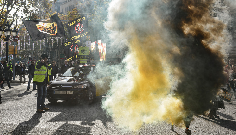 Varios manifestantes con bombas de humo durante una marcha lenta, a 9 de diciembre de 2025, en Barcelona, Catalunya (España)
