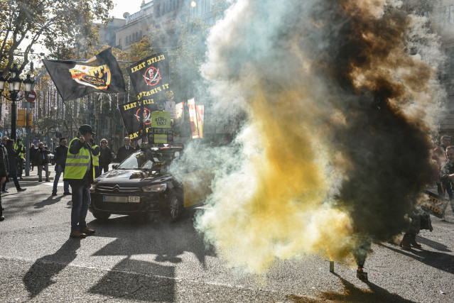 Varios manifestantes con bombas de humo durante una marcha lenta, a 9 de diciembre de 2025, en Barcelona, Catalunya (España)