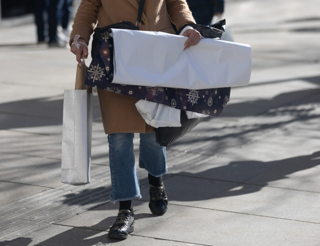 Archivo - Una persona lleva bolsas con regalos para Reyes, en Madrid (España)