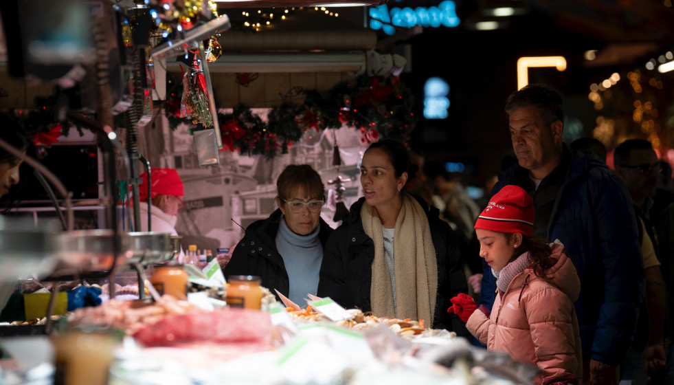 Archivo - Varias personas miran el género expuesto, en el Mercado de la Boquería, a 14 de diciembre de 2023, en Barcelona, Catalunya (España).