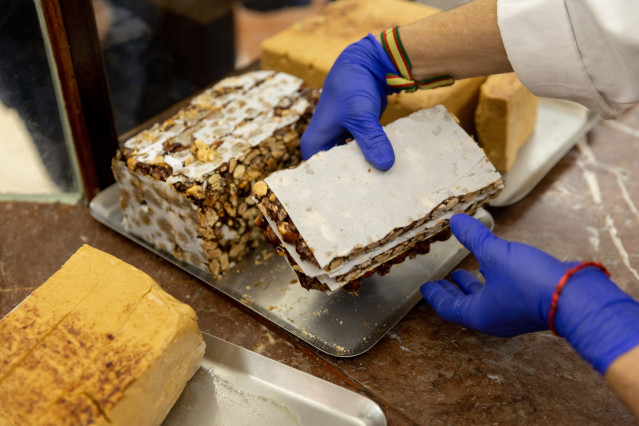 Archivo - Un pastelero muestra un bloque de turrón
