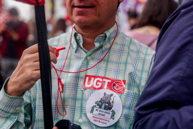 Archivo - Empleado del sector financiero con pegatinas de la UGT se concentra para pedir una compensación salarial.