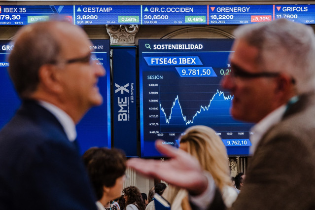 Archivo - (Foto de ARCHIVO) Varias personas frente a los paneles del Ibex 35 en el Palacio de la Bolsa