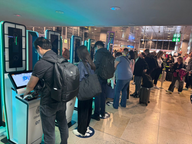 Archivo - Viajeros utilizando las cabinas supervisadas por la Policía Nacional instaladas en Madrid-Barajas. A 12 de octubre de 2025, Madrid.