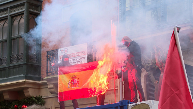Encapuchados queman una bandera española en el centro de Bilbao al paso de una manifestación de Ernai, juventudes de Sortu, por la independencia