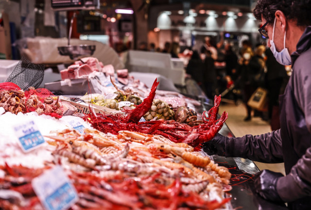 Archivo - Un vendedor en un puesto de marisco en Navidad