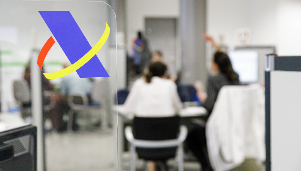 Archivo - Varias personas son atendidas en la Agencia Tributaria.