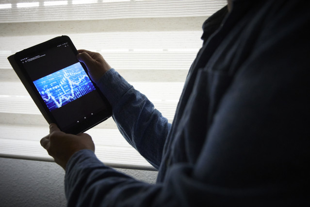 Archivo - Un hombre sujeta una tablet con un gráfico, a 4 de enero de 2022, en Madrid, (España).