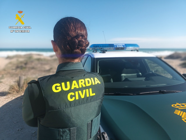Agente de la Guardia Civil junto a un vehículo