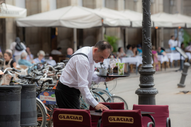 Archivo - Un camarero limpia una mesa en la plaza Real de Barcelona, a 15 de junio de 2022, en Barcelona, Cataluña (España).