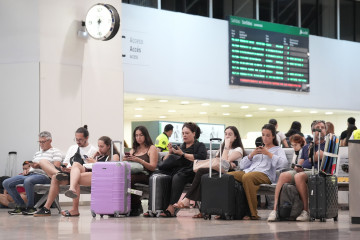 Archivo - Varias personas con maletas, en la estación de Sants, a 8 de agosto de 2025, en Barcelona, Catalunya (España).