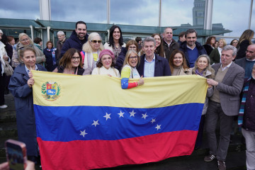 El presidente del Partido Popular, Alberto Núñez Feijóo (4d), y el presidente de la Xunta de Galicia, Alfonso Rueda (d), se reúnen con un grupo de venezolanos al término del acto de clausura de l