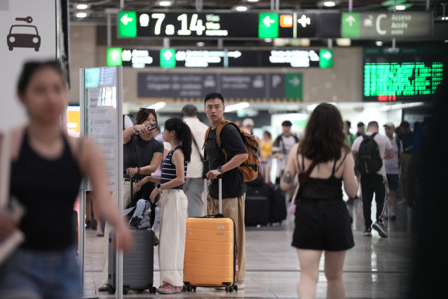 Archivo - Varias personas con maletas, en la estación de Sants de Barcelona.
