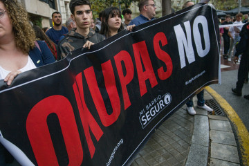 Archivo - Varias personas sujetan un cartel que reza 'Okupas no' durante una protesta en Barcelona