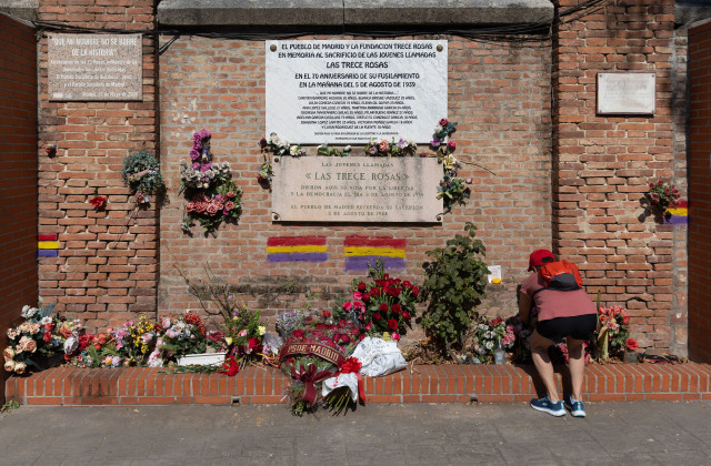 Archivo - Una persona coloca flores, durante el homenaje a Las Trece Rosas, en el Cementerio del Este, a 5 de agosto de 2025, en Madrid