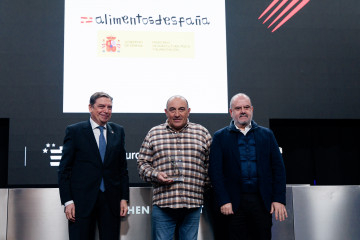 El ministro de Agricultura, Pesca y Alimentación, Luis Planas (i), entrega el premio Defensa del Producto al ganadero y cocinero de El Capricho, José Gordón (c), durante la visita a Madrid Fusión 