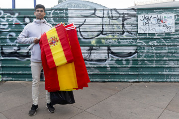 Archivo - Público portando banderas de España antes del acto solemne de homenaje a la bandera nacional y desfile militar por el 12 de octubre, Día de la Hispanidad, en la Plaza de Cánovas del Cast