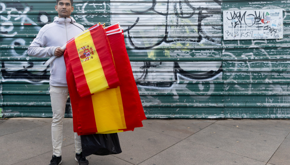 Archivo - Público portando banderas de España antes del acto solemne de homenaje a la bandera nacional y desfile militar por el 12 de octubre, Día de la Hispanidad, en la Plaza de Cánovas del Cast