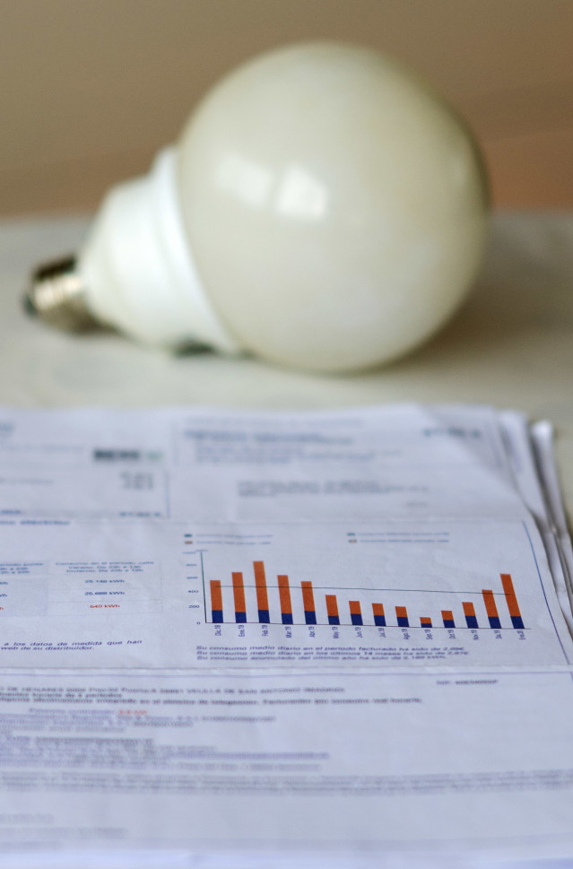 Archivo - Una factura de la luz y una bombilla