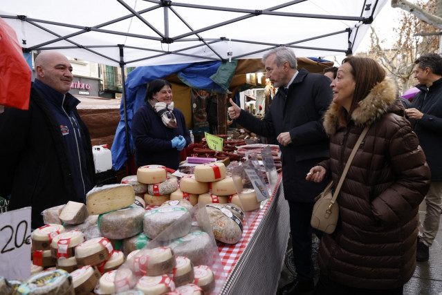 El candidato del PP a la Presidencia del Gobierno de Aragón, Jorge Azcón, junto a la número uno de la lista por la provincia de Huesca, Carmen Susín, este lunes en un puesto de la Feria de la Candelera.