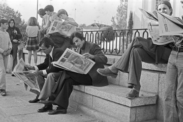 Simpatizantes y curiosos leyendo los periódicos en las inmediaciones del Palacio de El Pardo para conocer las novedades en la evolución del estado de salud de Franco