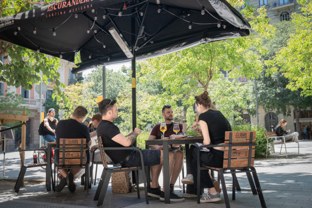 Archivo - Varias personas en la terraza de un bar