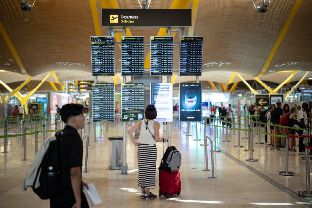 Archivo - Pasajera visualiza las pantallas, en el Aeropuerto Adolfo Suárez Madrid-Barajas, a 14 de agosto de 2025, en Madrid (España).