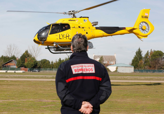 Archivo - Un miembro del efectivo de Bomberos de la Diputación de Valladolid observa un helicóptero de la Junta de Castilla y León que participa en la búsqueda de un ultraligero y a las dos personas que viajaban en él al norte y sur del río Duero, entre l
