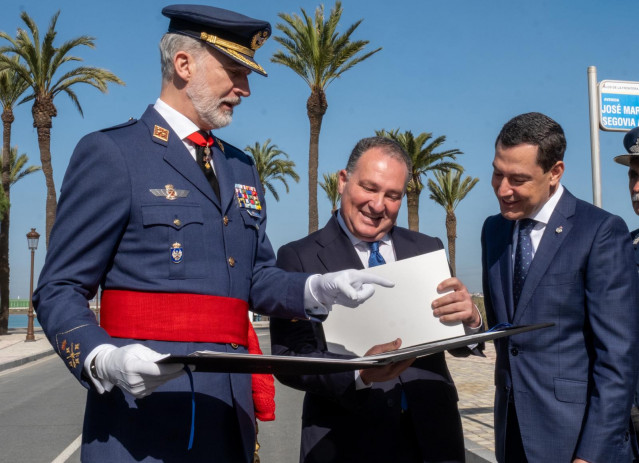 Felipe VI recibe una carpeta con fotos de La Rábida que había diseñado y traía en el tren María Clauss, fallecida en Adamuz. En la imagen, con el presidente de la Diputación de Huelva, David Toscano, y el presidente de la Junta, Juanma Moreno