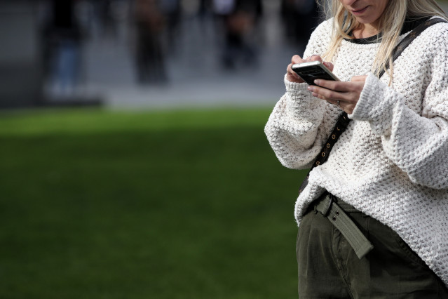 Archivo - Una mujer utiliza su móvil, en Madrid a 18 de noviembre de 2019.