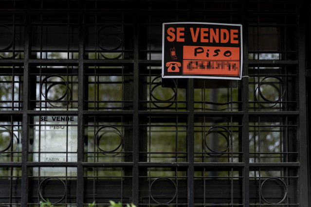 Archivo - Vista de un cartel de 'Se vende piso' en un portal de un edificio