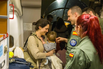 Una mujer y su bebé a la llegada a Madrid de los pasajeros evacuados desde Omán.