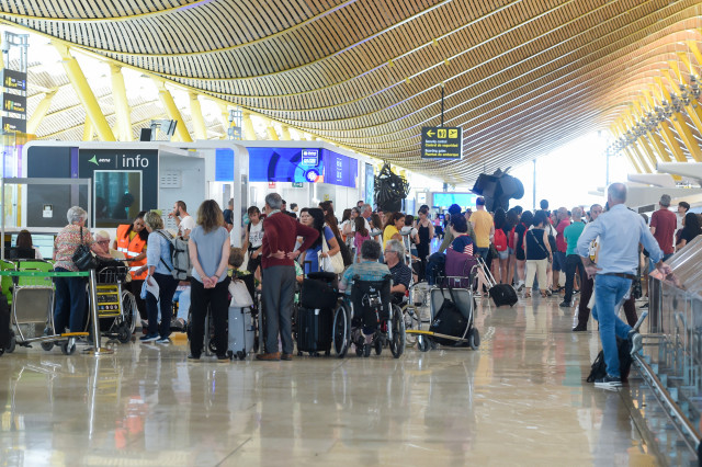 Archivo - Pasajeros esperan en la entrada de la Terminal 4 de Barajas.