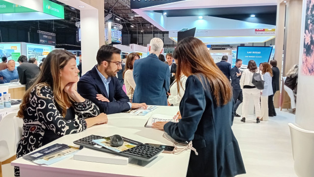 Una pareja recibe información de la oferta de Aedas Homes en el SIMA.