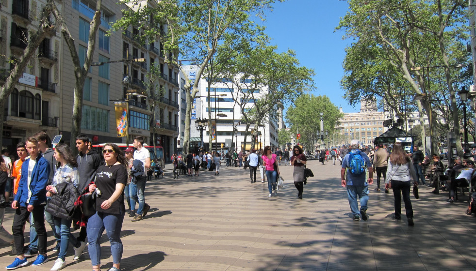 Archivo - Personas paseando por una calle en Barcelona.