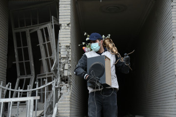 EuropaPress 7367536 beijing march 15 2026    man carries belongings searched from destroyed (1)