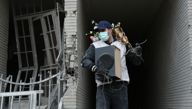 EuropaPress 7367536 beijing march 15 2026    man carries belongings searched from destroyed (1)