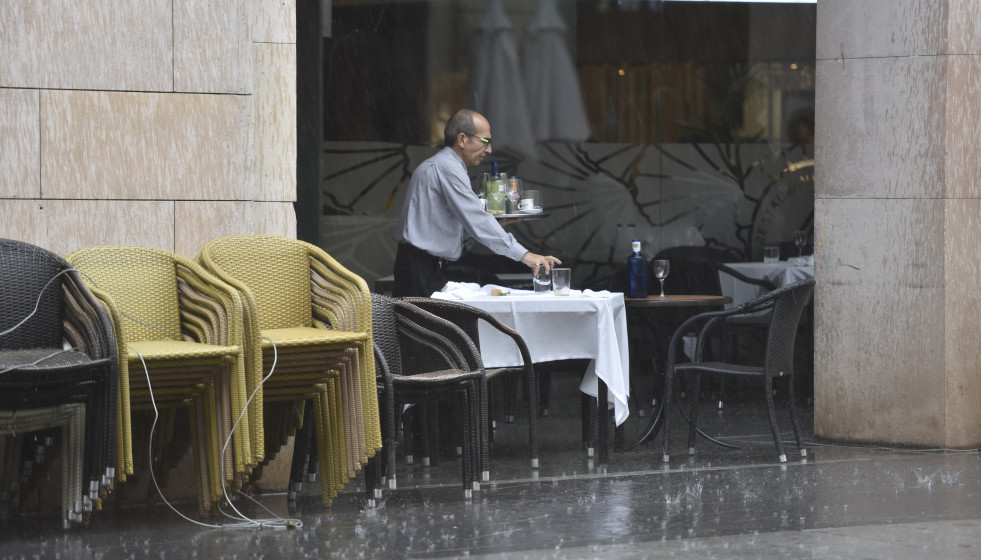 Archivo - Un camarero recogiendo una mesa en una terraza